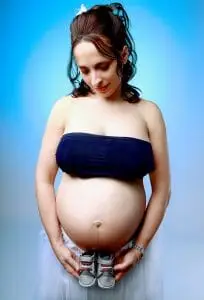 Shooting Grossesse Enceinte avec chausson bébé fond bleu